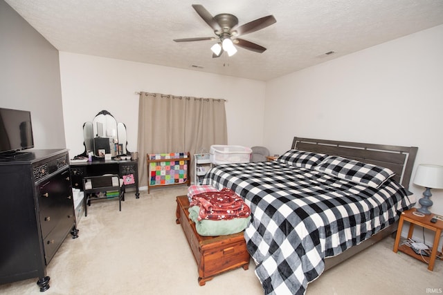 carpeted bedroom with ceiling fan and a textured ceiling