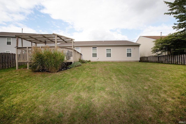 back of property with a pergola, a wooden deck, and a yard