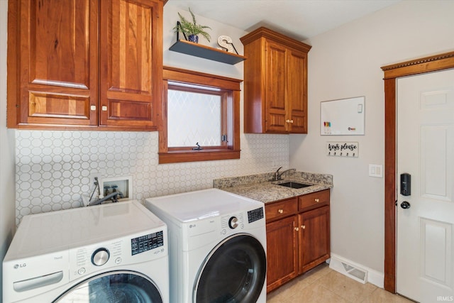 washroom with separate washer and dryer, sink, light tile patterned floors, and cabinets