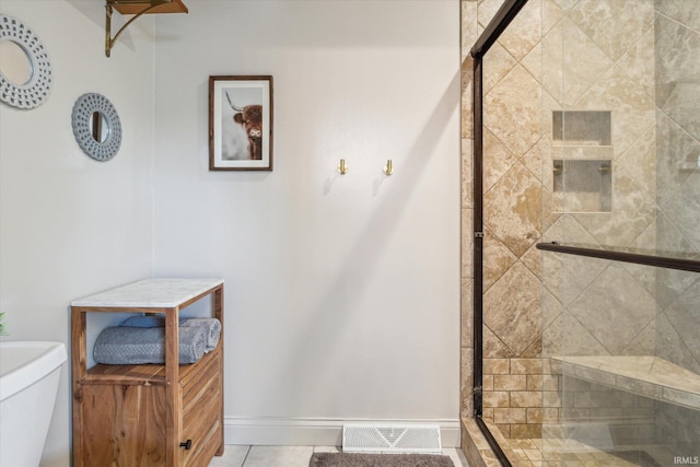 bathroom featuring tile patterned floors, toilet, and an enclosed shower