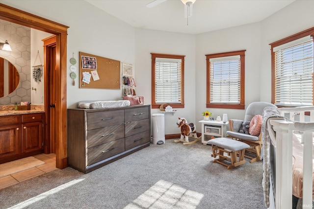 bedroom with ceiling fan, connected bathroom, and light carpet