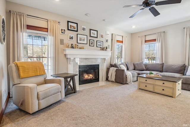 carpeted living room with ceiling fan and a fireplace