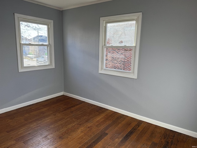 empty room featuring hardwood / wood-style floors, ornamental molding, and a healthy amount of sunlight