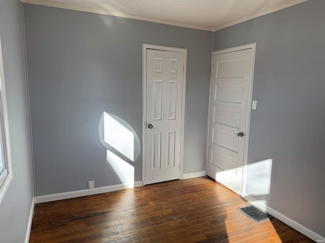 unfurnished room with ornamental molding and dark hardwood / wood-style floors