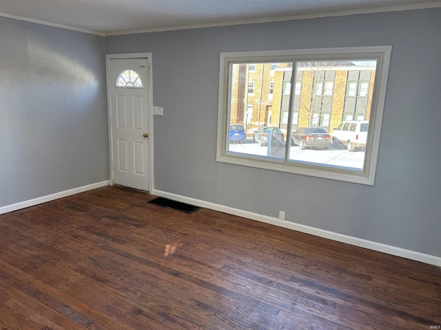 foyer entrance with dark wood-type flooring and crown molding