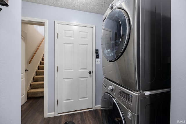 washroom with stacked washer / dryer, dark wood-type flooring, and a textured ceiling