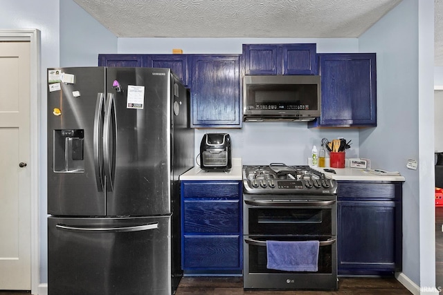 kitchen featuring blue cabinetry, appliances with stainless steel finishes, and dark wood-type flooring