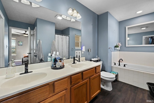 full bathroom with ceiling fan, hardwood / wood-style floors, vanity, shower with separate bathtub, and toilet