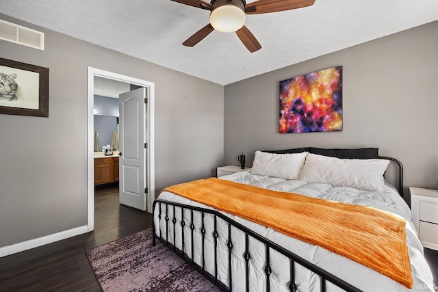 bedroom with ceiling fan, ensuite bathroom, dark hardwood / wood-style floors, and a textured ceiling