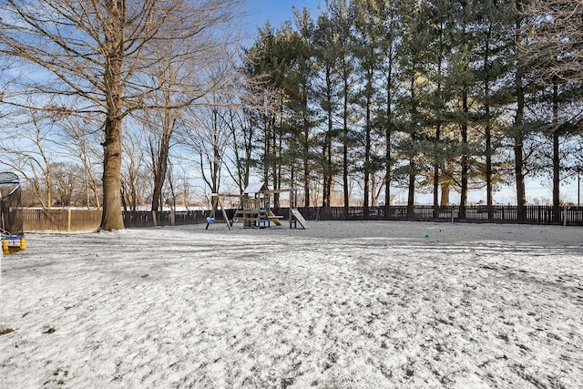 snowy yard featuring a playground