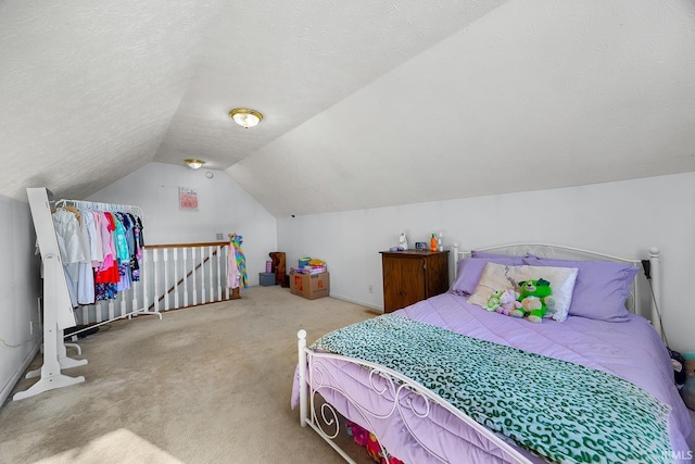 bedroom featuring lofted ceiling, carpet floors, and a textured ceiling