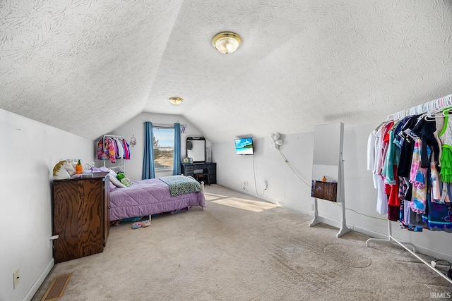 carpeted bedroom with vaulted ceiling and a textured ceiling