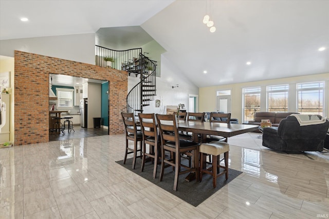 dining space with high vaulted ceiling