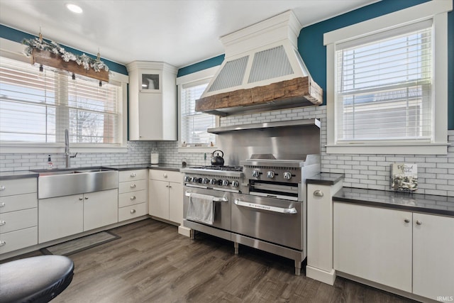 kitchen featuring white cabinetry, sink, range with two ovens, dark wood-type flooring, and custom range hood