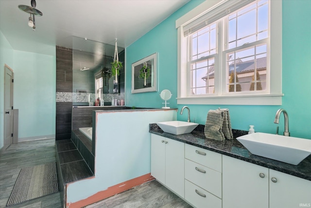 bathroom featuring vanity and a relaxing tiled tub