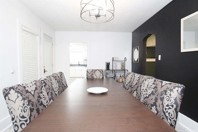 dining space featuring sink and an inviting chandelier