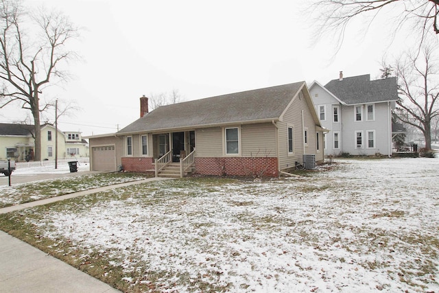 view of front facade featuring a garage and central air condition unit