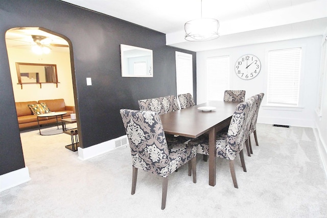 dining space with light carpet and ceiling fan