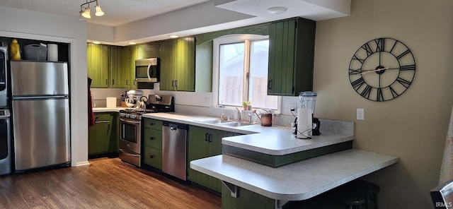 kitchen featuring dark hardwood / wood-style floors, stainless steel appliances, sink, and green cabinets