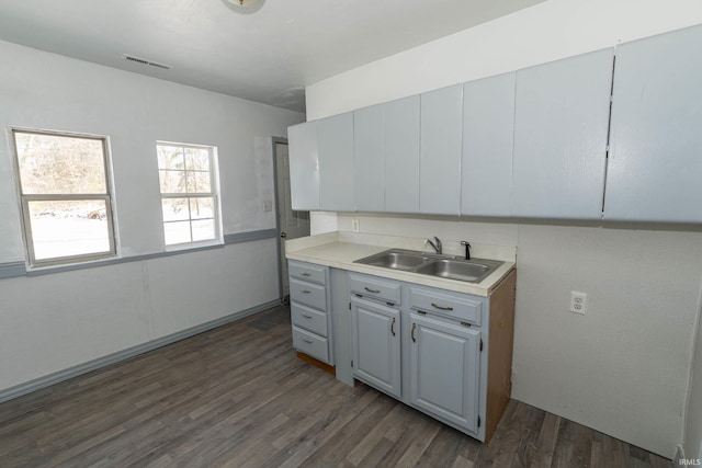 kitchen with sink, dark wood-type flooring, and gray cabinets