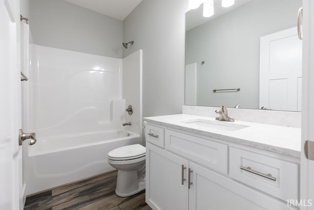 full bathroom with wood-type flooring, toilet, shower / bathing tub combination, and vanity