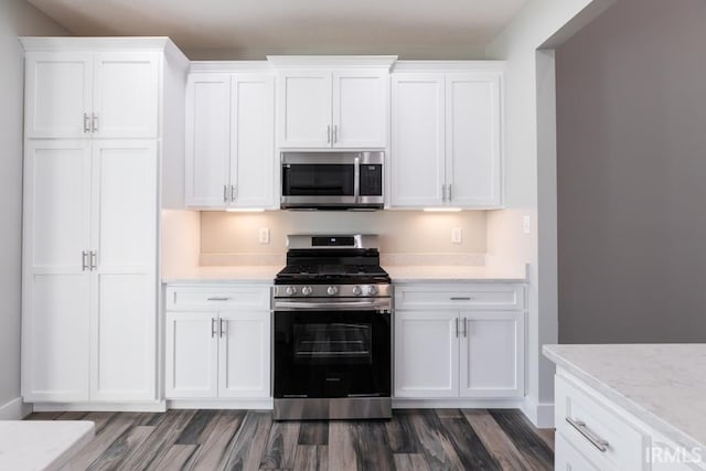 kitchen featuring stainless steel appliances, dark hardwood / wood-style floors, and white cabinets