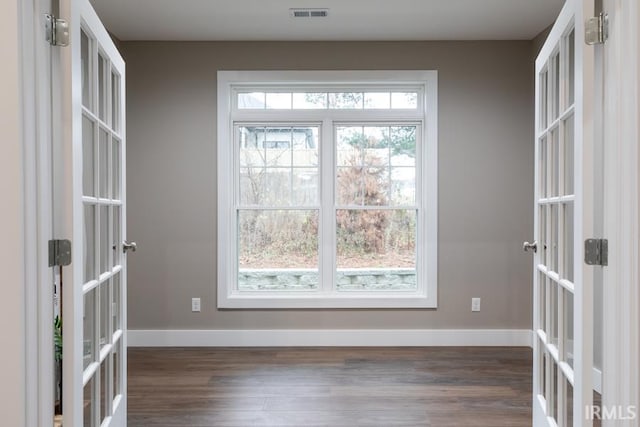 empty room featuring dark hardwood / wood-style flooring and french doors