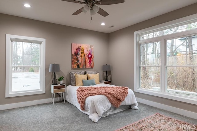 carpeted bedroom featuring ceiling fan and multiple windows