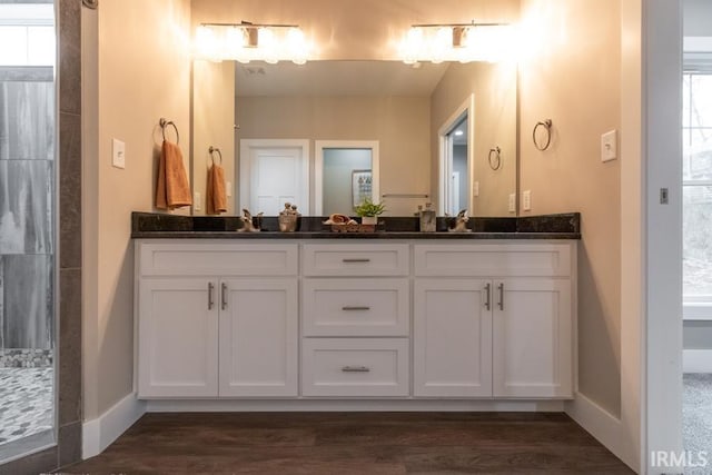 bathroom featuring hardwood / wood-style flooring, vanity, and a shower