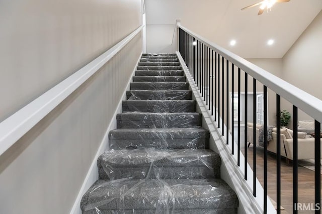 stairway with ceiling fan and hardwood / wood-style floors