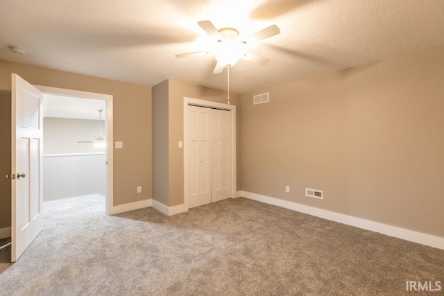 unfurnished bedroom featuring carpet flooring, ceiling fan, and a closet