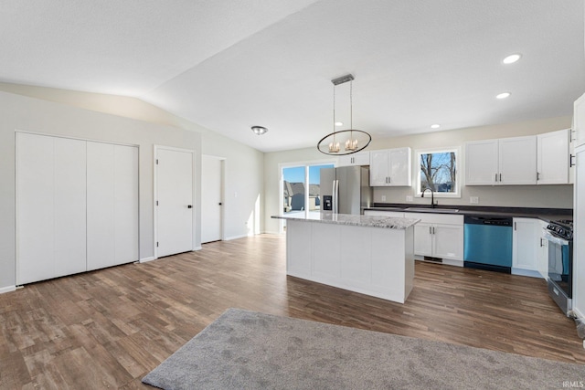 kitchen with stainless steel appliances, a kitchen island, pendant lighting, and white cabinets