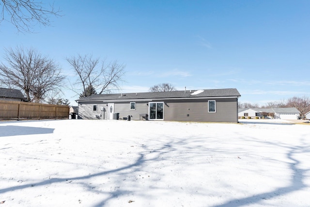 view of snow covered back of property