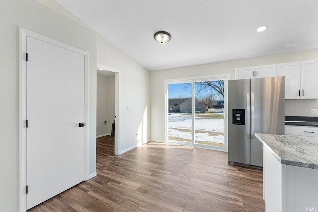 unfurnished dining area with vaulted ceiling and dark wood-type flooring