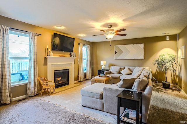 living room featuring ceiling fan, carpet flooring, and a textured ceiling