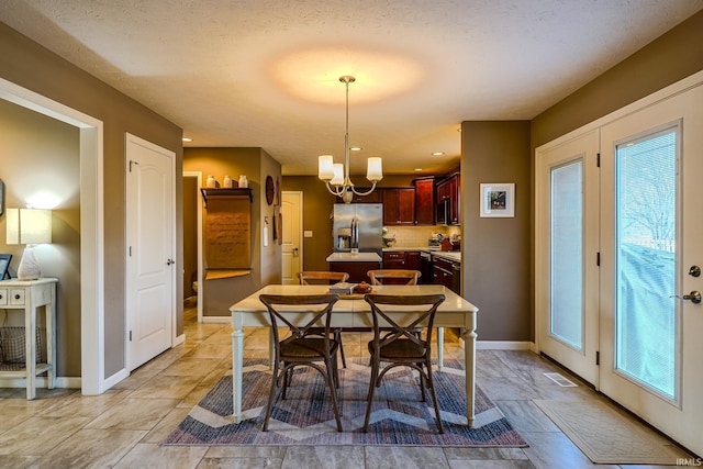 dining room with an inviting chandelier and a textured ceiling