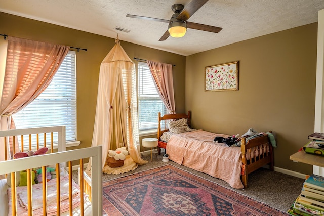 bedroom featuring ceiling fan, carpet flooring, and a textured ceiling