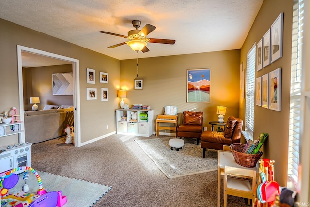 game room featuring ceiling fan, carpet, and a textured ceiling