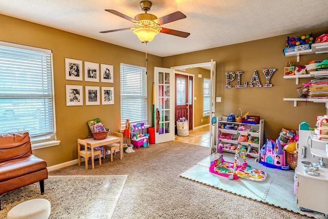 rec room featuring light carpet, french doors, and ceiling fan