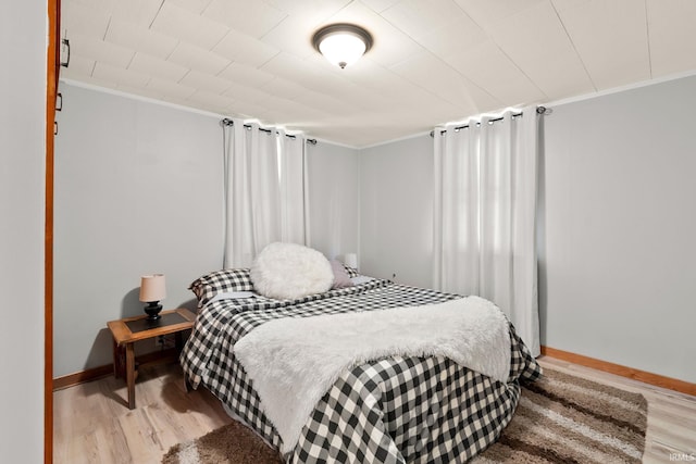 bedroom with crown molding and light hardwood / wood-style flooring