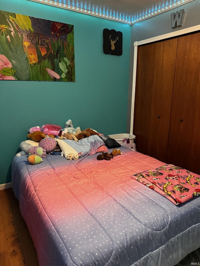 bedroom with wood-type flooring and a closet