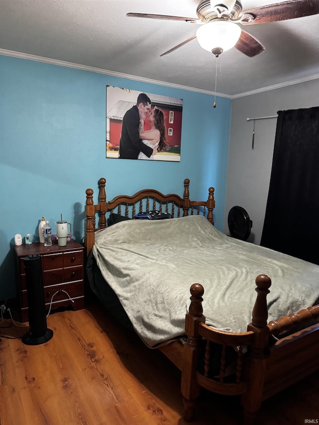 bedroom with ceiling fan, ornamental molding, and hardwood / wood-style floors