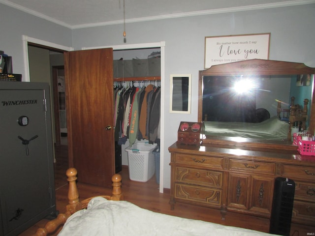 bedroom featuring ornamental molding, dark wood-type flooring, and a closet