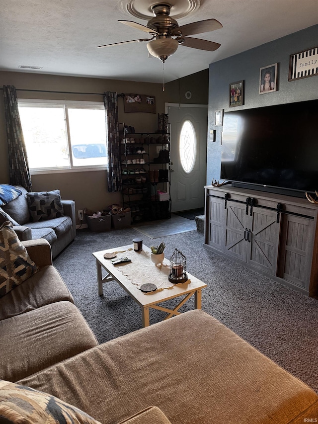 carpeted living room with a textured ceiling, vaulted ceiling, and ceiling fan