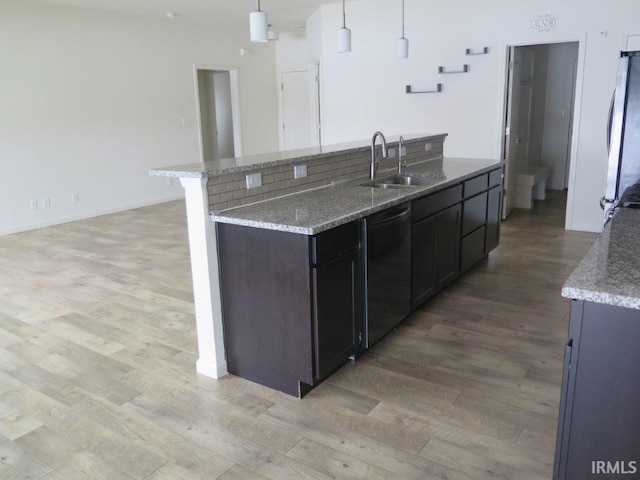 kitchen featuring sink, hanging light fixtures, light hardwood / wood-style flooring, stainless steel fridge, and black dishwasher