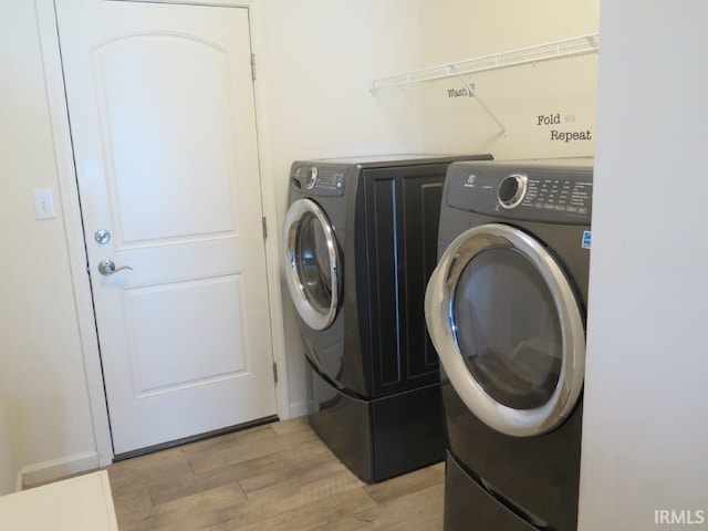 laundry room featuring separate washer and dryer and light wood-type flooring