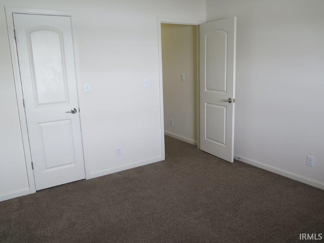 unfurnished bedroom featuring dark carpet