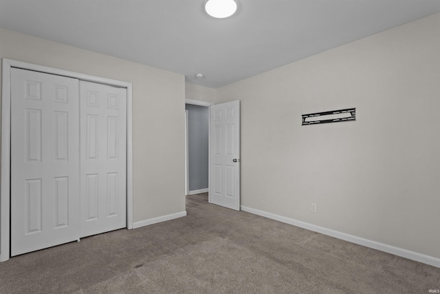 unfurnished bedroom featuring light carpet and a closet