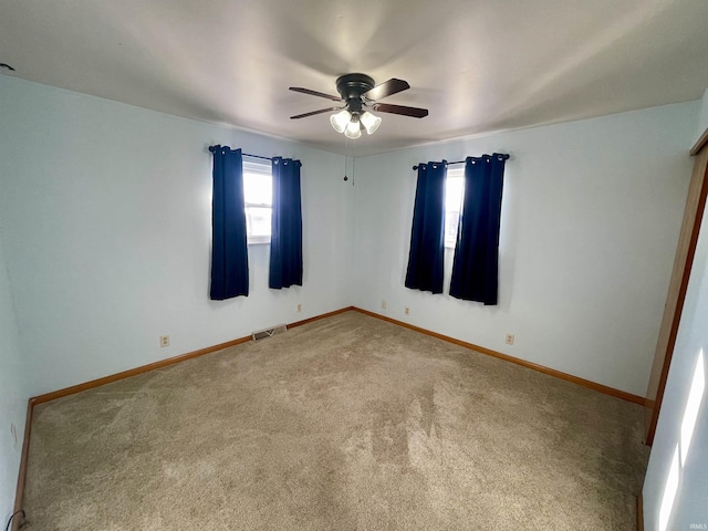 empty room with ceiling fan and carpet