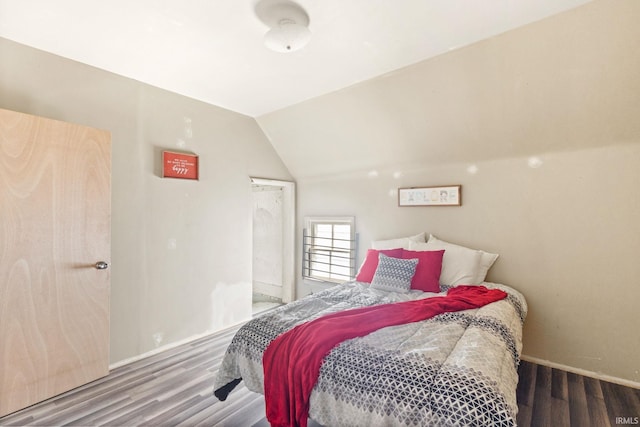 bedroom with lofted ceiling and hardwood / wood-style flooring